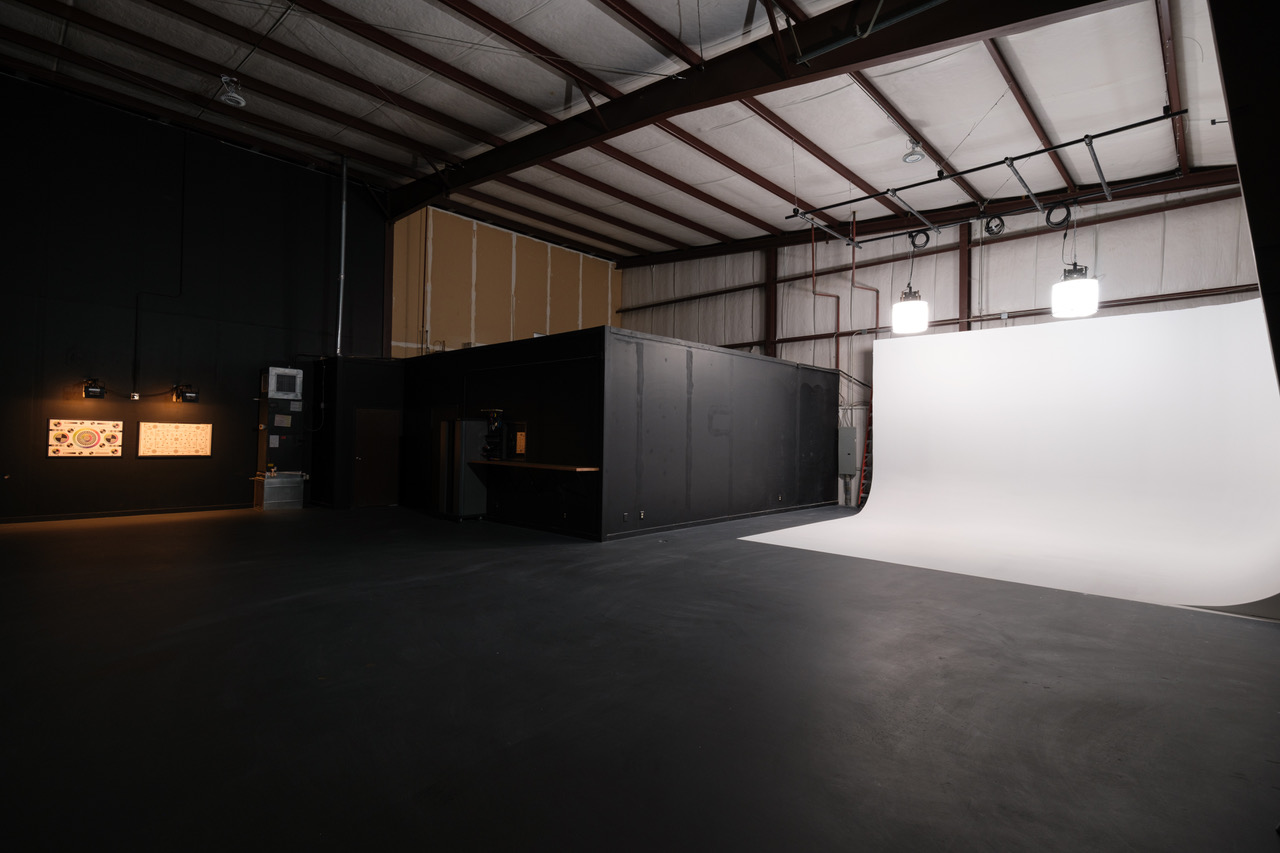 Full view of studio space showing off spacious area, pre-lit white cyc wall, and camera calibration station.